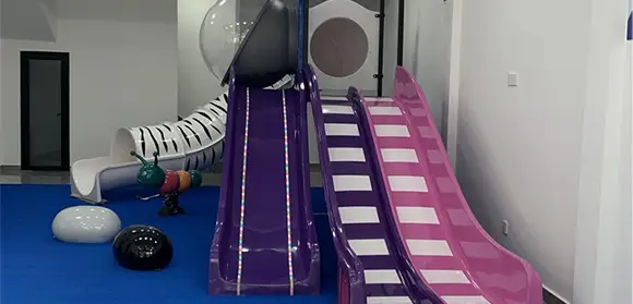 Slide in fibra di vetro in u campu di ghjocu per i zitelli